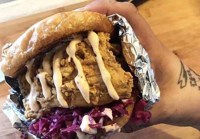 Vegan & Sara's The Con sando features a spicy fried chick’n topped with creamy sweet pepper slaw in a serrano aioli on a toasted bun. - INSTAGRAM / VEGANANDSARA14