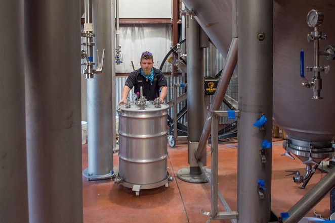 Head brewer Gregg Spickler moves fermentation tanks which yield CO2 naturally as a byproduct of beer making. - COURTESY OF ALAMO BEER CO.