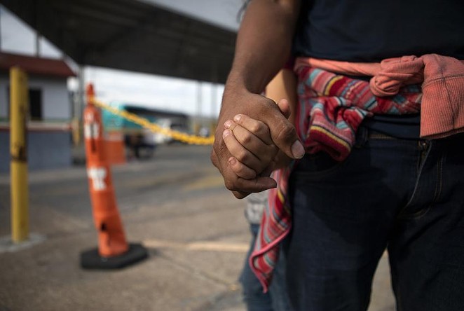 A Honduran migrant holds his daughter’s hand at an immigration checkpoint in Nuevo Laredo. - THE TEXAS TRIBUNE / MIGUEL GUTIERREZ JR.