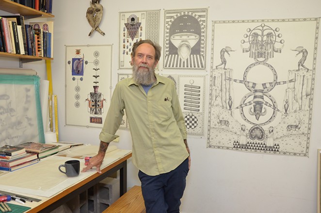 Artist James Smolleck in his home studio with recent works including the 2021 drawing The Goblin Scapegoat. - BRYAN RINDFUSS