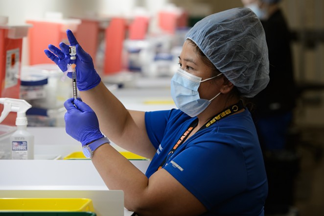 A health worker prepares a syringe at a San Antonio vaccination clinic. - COURTESY PHOTO / UNIVERSITY HEALTH SYSTEM