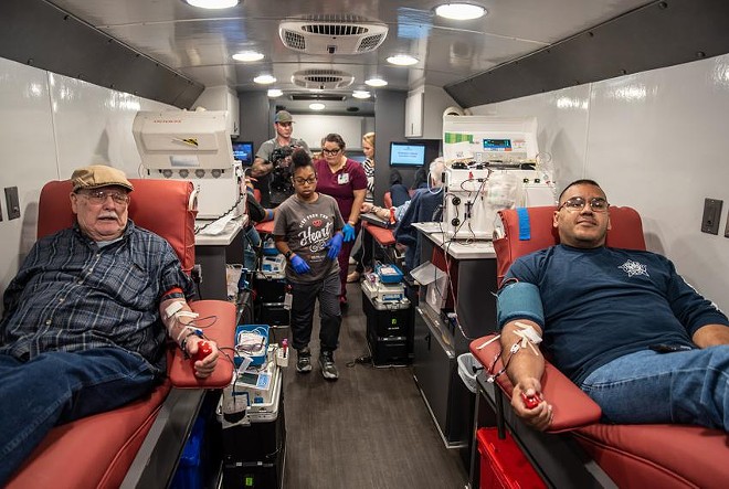 Bobby Kramer, 84, and Charlie Garvan, 52, sit next to each other as they donate blood at the Herby Ham Activity Center on Wednesday, May 25, 2022, in Uvalde. Community members gathered to donate blood after a school shooting took place Tuesday. - Texas Tribune / Sergio Flores