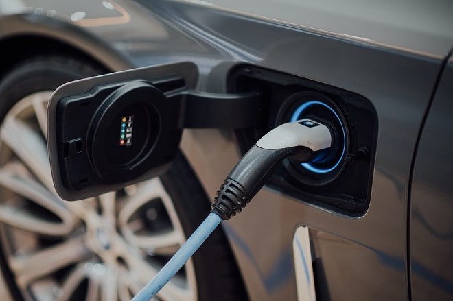 An electric vehicle charges up at a station. - UNSPLASH / CHUTTERSNAP