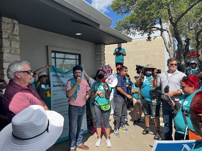Congressional candidate Greg Casar (speaking into megaphone) addresses protesters Monday outside the offices of Achievement Investment Group. - Courtesy Photo / Greg Casar