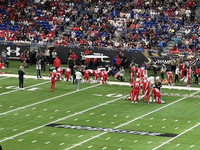 Players from the DC Defenders took a knee while San Antonio photojournalist Tony Morano received medical during the XFL Championship game at the Alamodome. - Michael Karlis