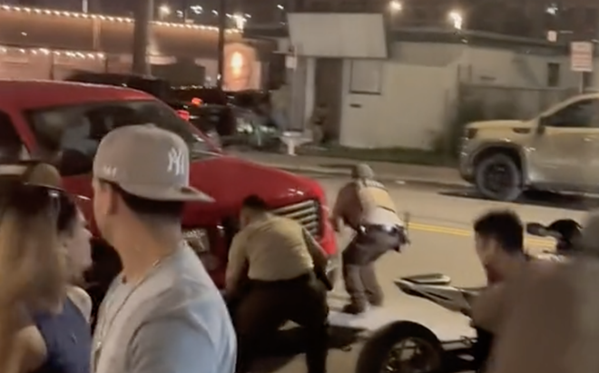 Security guards at Bentley's Beer Garden in San Antonio duck behind a car after shots erupt in front of the downtown bar. - TikTok / @thathandsomebritishguy