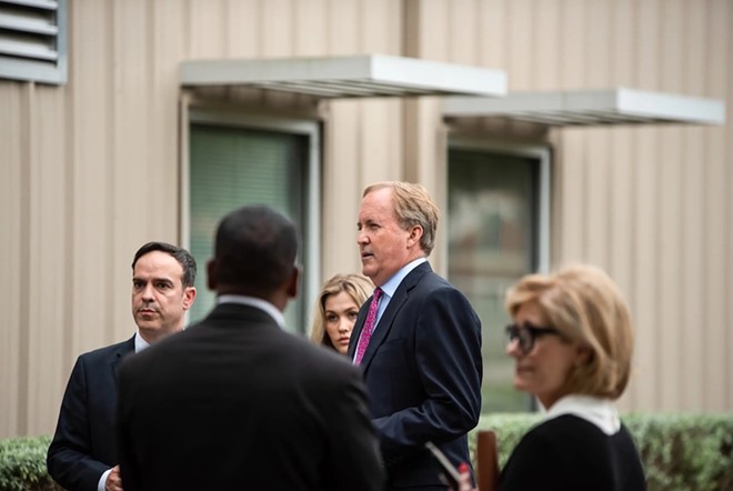 State Attorney General Ken Paxton, right, talks with staff members before a press conference at the Houston Recovery Center on Oct. 26, 2021. - Texas Tribune / Mark Felix