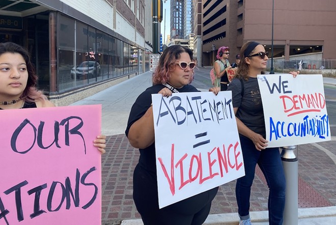 Protesters hold up signs in front of San Antonio city offices demanding accountability for the treatment of the community's unhoused population. - Sanford Nowlin