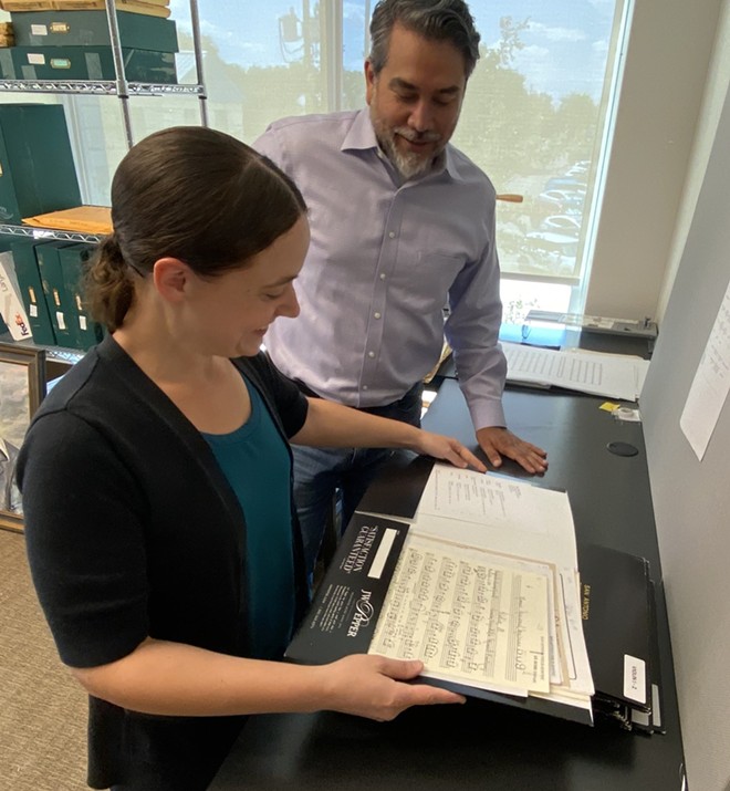 Executive Director Roberto Treviño (right) looks over sheet music with Alison Bates, the orchestra librarian, at the San Antonio Philmarmonic’s new office. - Sanford Nowlin