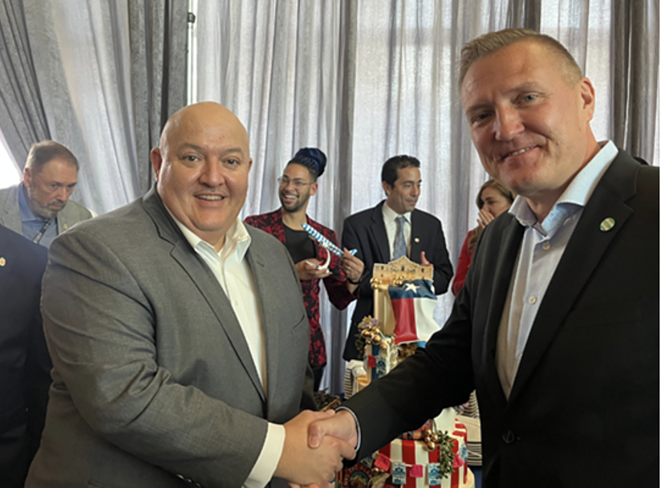 Airport Director Jesus Saenz shakes hands with Mikko Turtiainen, U.S. sales director for Condor Airlines, at Thursday's press event. - Brandon Rodriguez