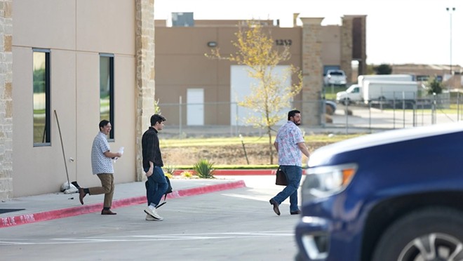 Nick Fuentes (middle) is seen exiting the offices of Pale Horse strategies with Chris Russo, founder and president of Texans for Strong Borders (right) outside of Fort Worth on Oct. 6, 2023.
