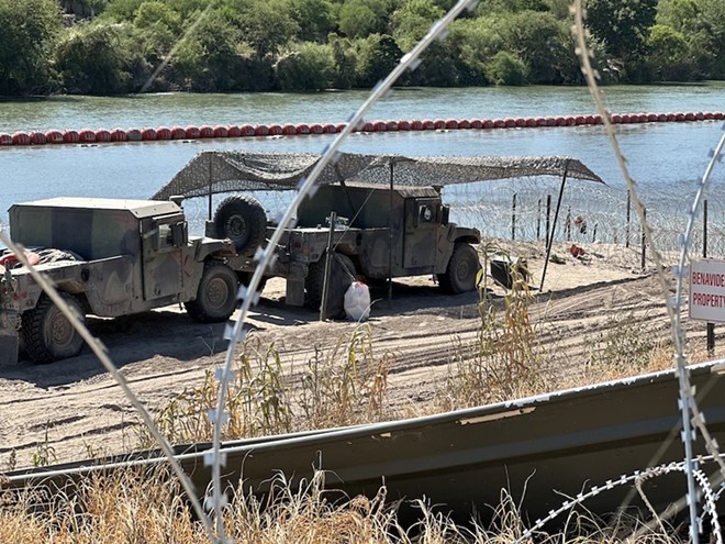 These vehicles along the Rio Grande are part of the state's effort to thwart border crossings. - Michael Karlis