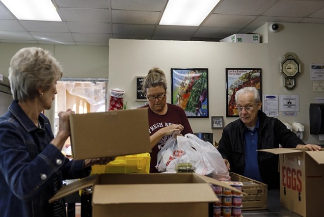 Volunteers from left to right, Evelyn McMillen, Leigh Cox and Victor Surita help to package orders of groceries at El Buen Samaritano food pantry in Austin on Nov. 14. - Texas Tribune / Julius Shieh