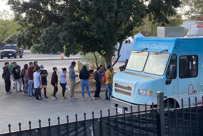 People at San Antonio's Migrant Resource Center line up for provisions from nonprofit group Catholic Charities. - Sanford Nowlin