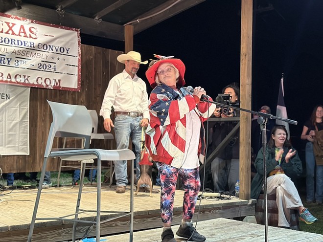 Self-described "Mama Bear" and convoy member Mona Miller recites a poem about the virtues of the American flag amid loud applause from rally attendees. - Michael Karlis