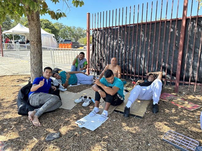 A group of Venezuelan migrants take refuge from the Texas sun under a tree outside San Antonio's Migrant Resource Center last autumn. - Michael Karlis