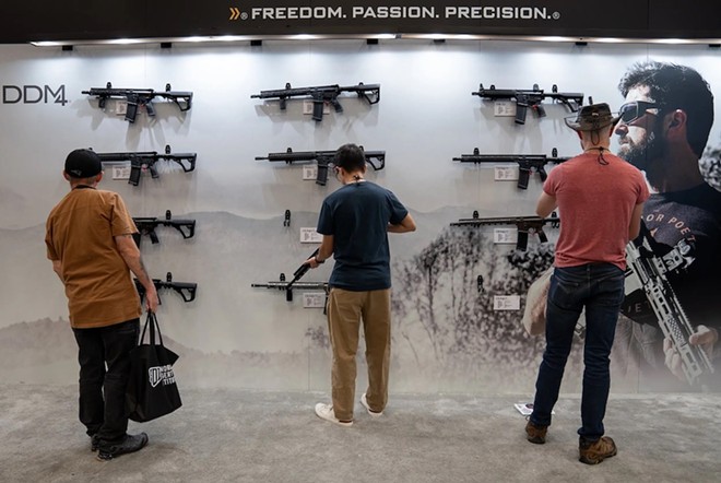 Attendees browse the Daniel Defense firearms booth at the NRA Annual Meetings and Exhibits at the Kay Bailey Hutchison Convention Center in Dallas on May 17, 2024. - Texas Tribune / Azul Sordo