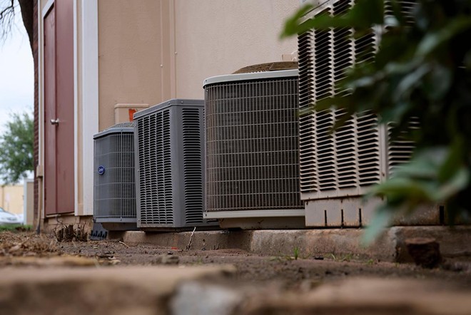 A group of air conditioning units sit outside of Estrella’s Midland apartment. - Texas Tribune / Reilly Strand