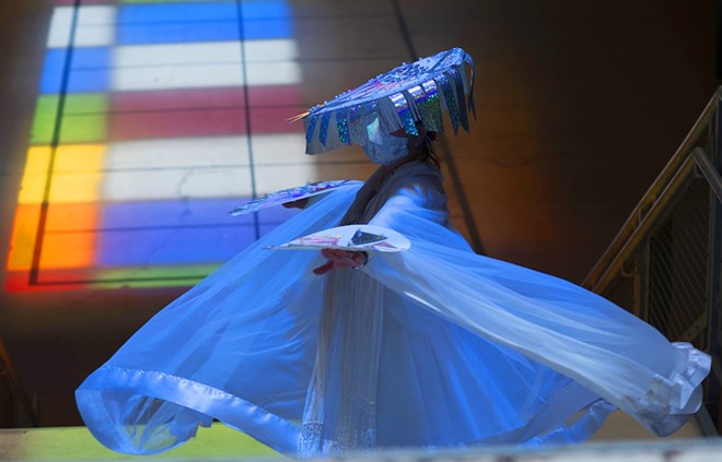 Light washes over a costumed dancer in one of Urban-15's Summer Solstice performances. - Courtesy Photo / Urban-15