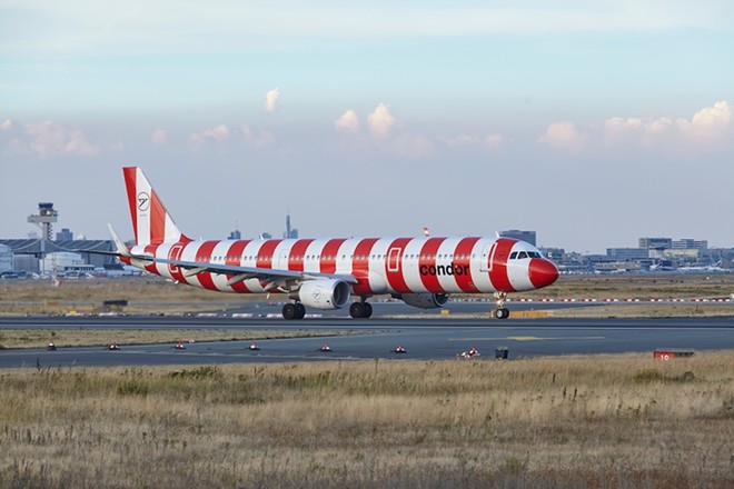 A red and white striped Condor aircraft lands at Frankfurt Main Airport in 2022. - Shutterstock / Olaf Schulz