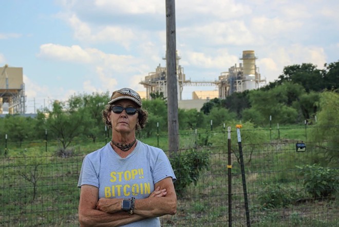 Cheryl Shadden stands outside her home in Granbury with a view of Constellation Energy's Wolf Hollow II power plant in the background. - Inside Climate News / Keaton Peters