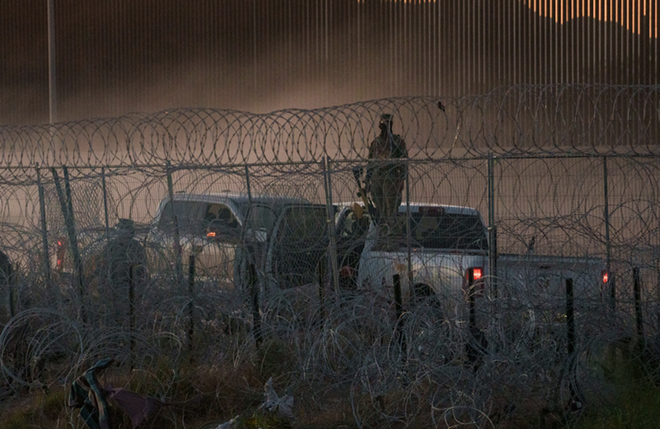 Armed personnel stand guard at the U.S.-Mexico border. - Courtesy Photo / Hope Border Institute