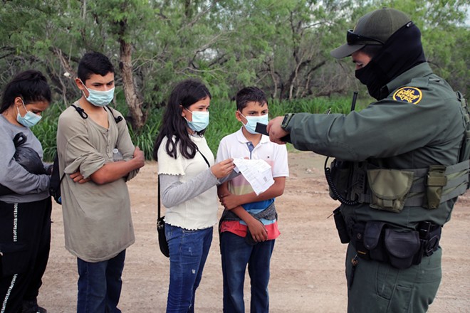 A Border Patrol agent processes a group of unaccompanied Central American minors who crossed the Rio Grande River. - Shutterstock / Vic Hinterlang