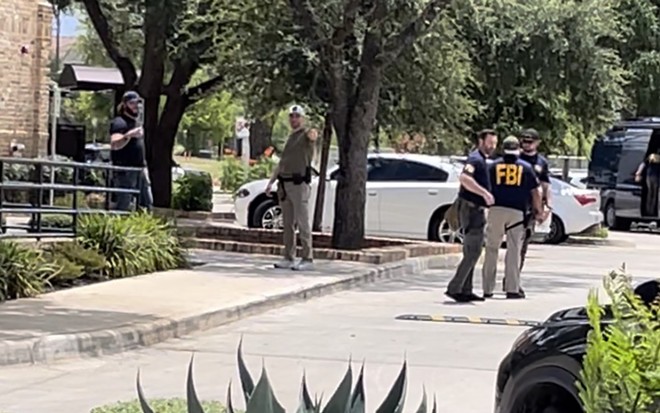 FBI agents and police officers are stationed around the parking lot of Delia's Tamales in Northwest San Antonio. - Adam Doe