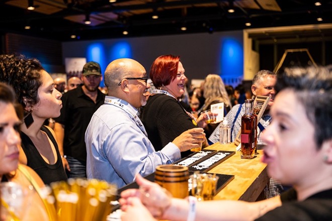 Revelers enjoy spirits and food at a previous Whiskey Business event. - Jaime Monzon