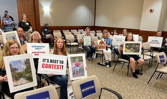 Opponents of a permit to discharge wastewater into Helotes Creek display their signs during a hearing in Austin on Wednesday. - Photo courtesy of Greater Edwards Aquifer Alliance