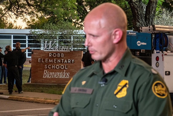 A U.S. Customs and Border Protection agent speaks to a reporter near the scene of a mass shooting at Robb Elementary School on May 24, 2022, in Uvalde. - Texas Tribune / Sergio Flores