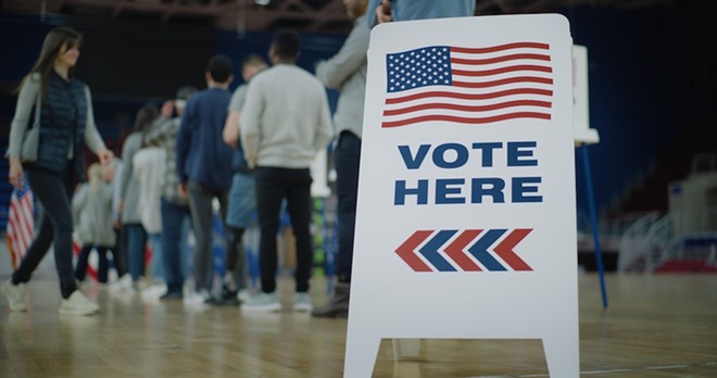 Voters line up to cast ballots at a polling location. - Shutterstock / Frame Stock Footage