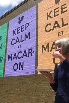 Kathy Sosa eats a macaron in front of the new mural.