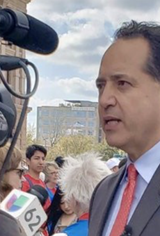 Texas Sen. Jose Menendez speaks to TV news crews outside the state capitol.
