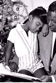 Cole, on the lap of her legendary father, a man she would grow to be considered equal to as a vocalist
