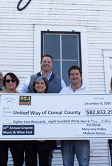 Sponsorship representatives present a check to United Way of Comal County.