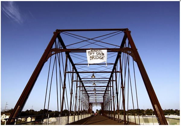 Activists climbed the Hays Street Bridge to hang a banner opposing development after plans for a brewery on public land emerged in 2012. - MICHAEL BARAJAS