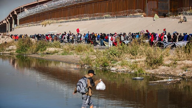Hundreds of migrants wait in line along the banks of the Rio Grande to seek asylum in the U.S. on Dec. 12.